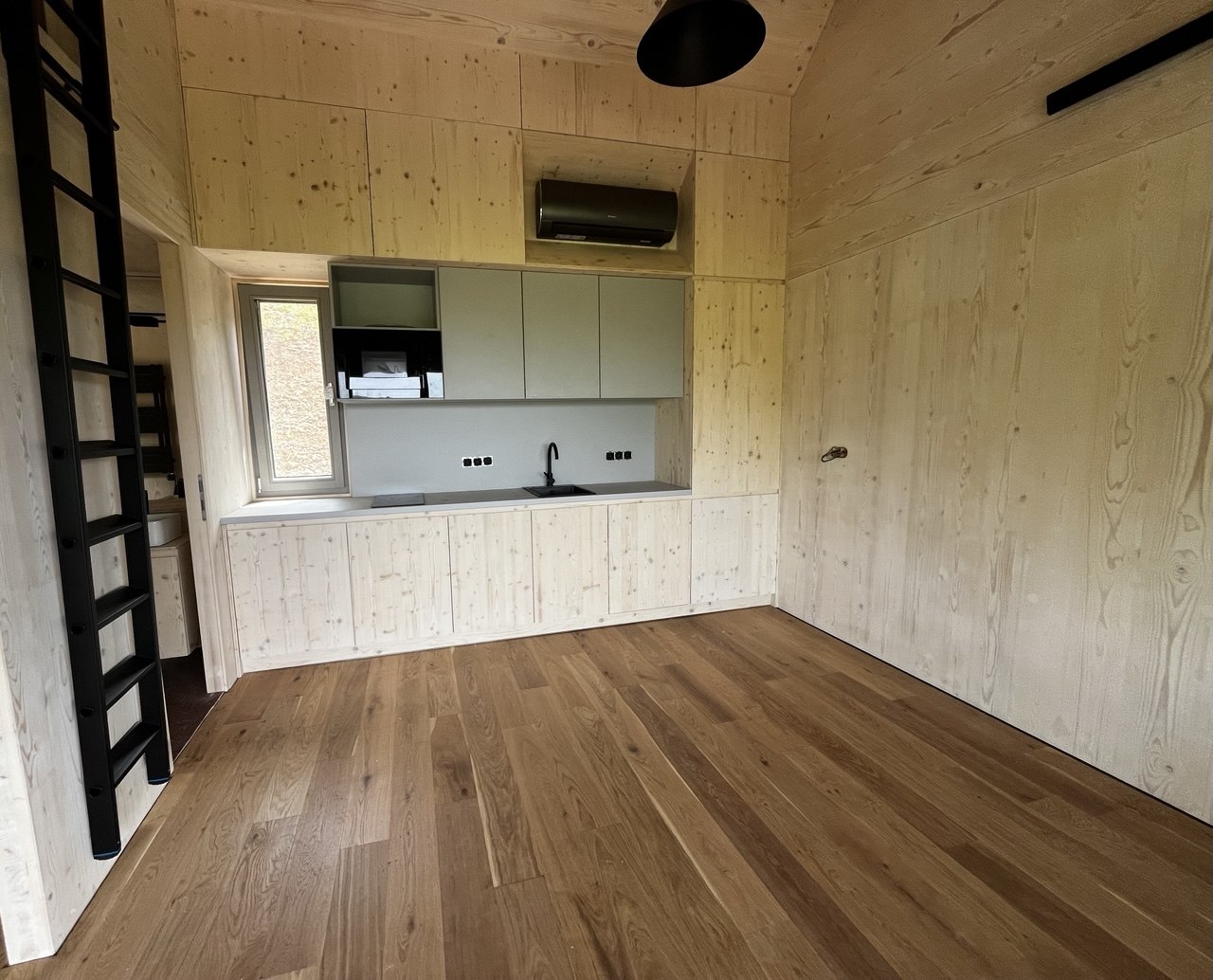 Tiny house belső tér – CLT faburkolatú falak, beépített konyha és tetőlétra